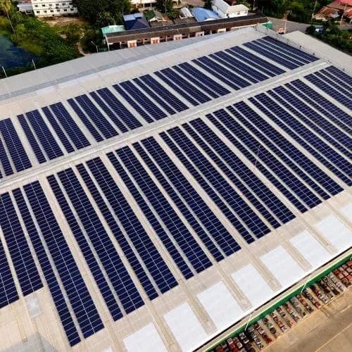 Rooftop solar array seen from above Aerial view of a large factory rooftop fully covered with rows of solar panels