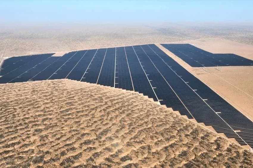 Luchtopname van rijen zonnepanelen naast zandduinen in de Tengger-woestijn in China
