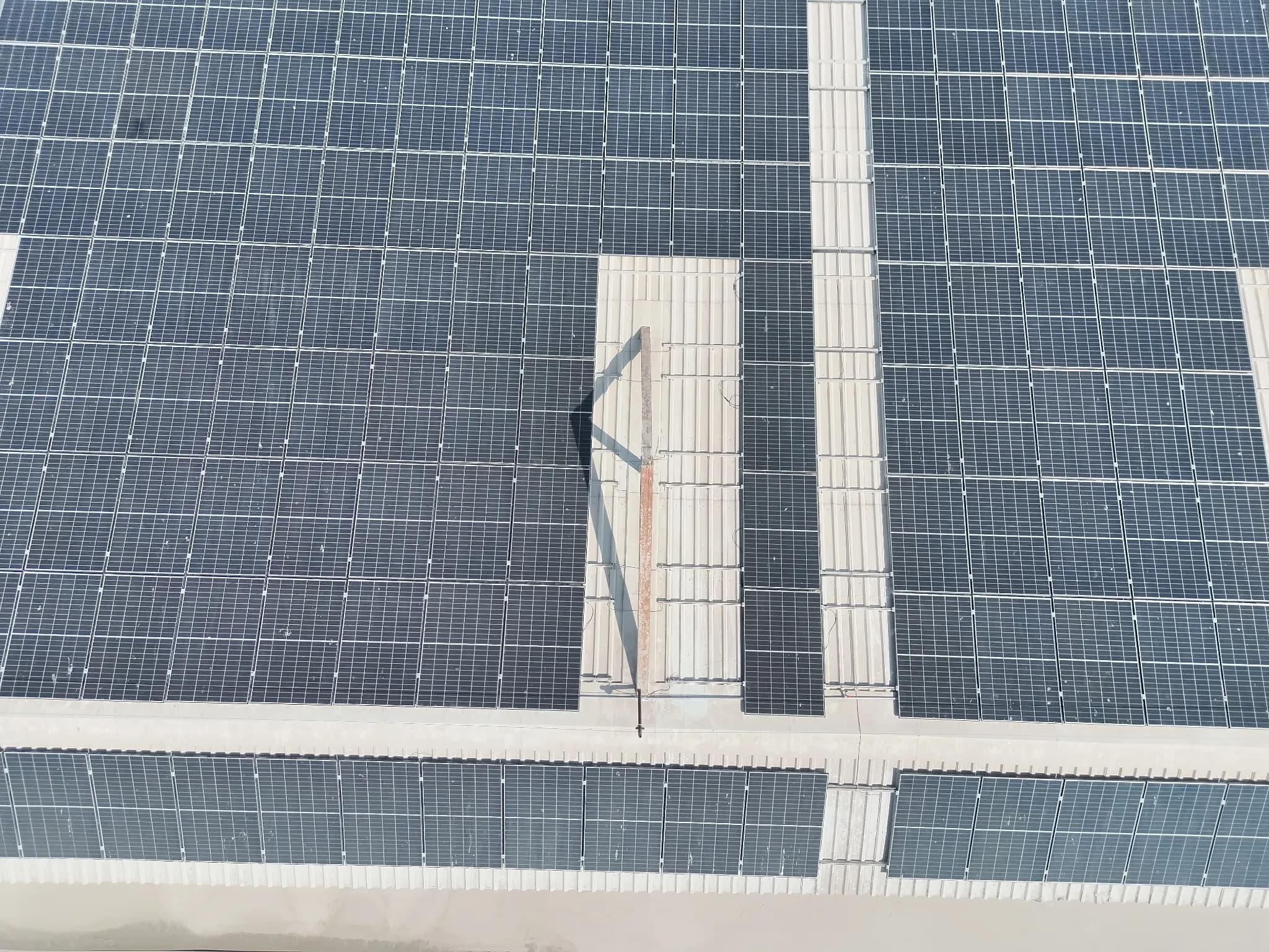 Aerial view of rooftop solar panels with shadows from a raised structure Aerial view of rooftop solar panels with shadows from a raised structure