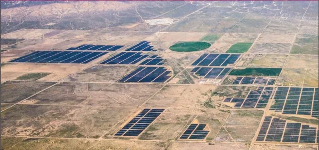 Luchtopname van verspreide velden met zonnepanelen op droog land