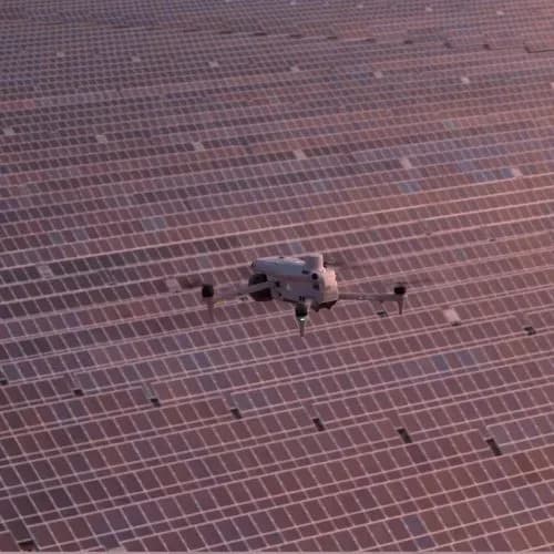 Drone au-dessus d’un vaste champ de panneaux Drone en vol au-dessus d’un vaste champ de panneaux solaires, vu à la verticale